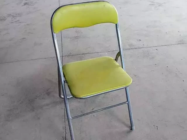 Silla plegable metálica de color amarillo